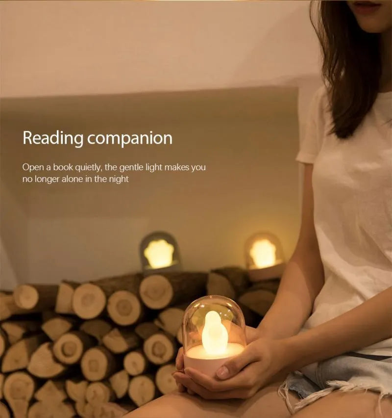 Grey cat paw shaped USB rechargeable musical night light on a wooden desk