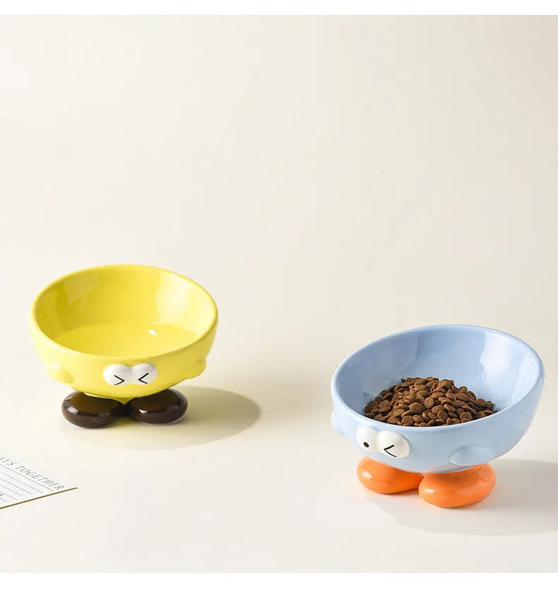 Oblique ceramic pet bowl with cute expression pattern, tall design for cervical spine protection