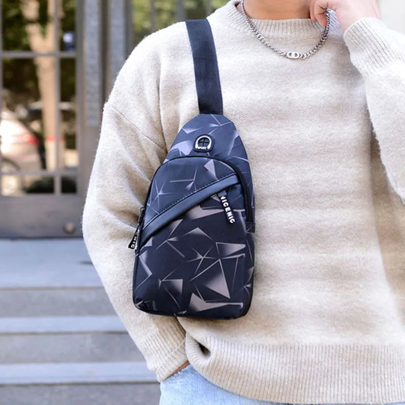 Men's blue print sling chest crossbody bag showing earphone hole and zipper pocket.