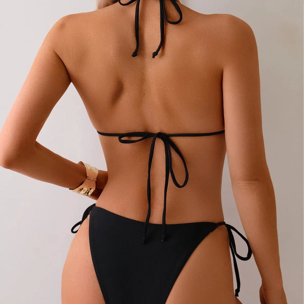 Black women's bikini swimsuit with split leg design and decorative metal bead.