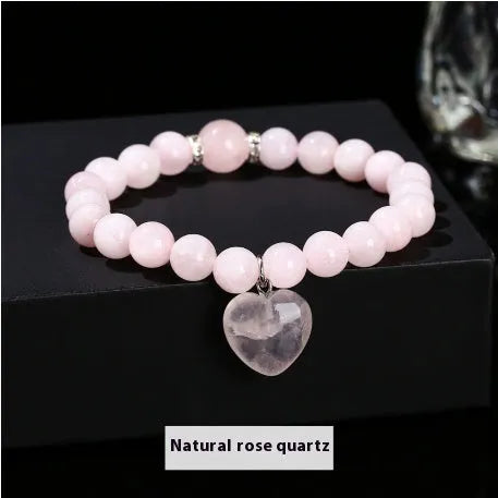 Handmade natural crystal love pendant bracelet with round beads in tiger's eye, aventurine, and white jade on a white background