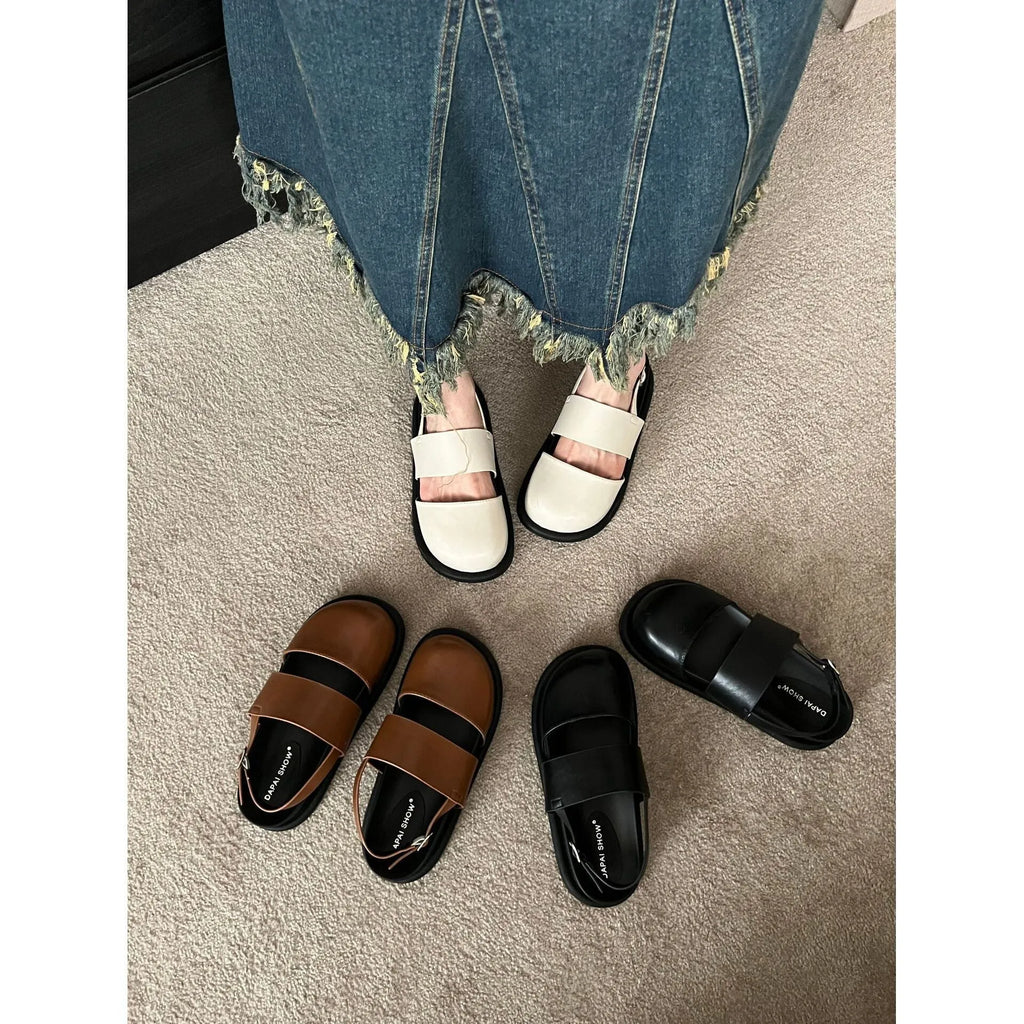 Korean style women's retro sandals with a black microfiber upper and adjustable ankle buckle on a PVC sole.