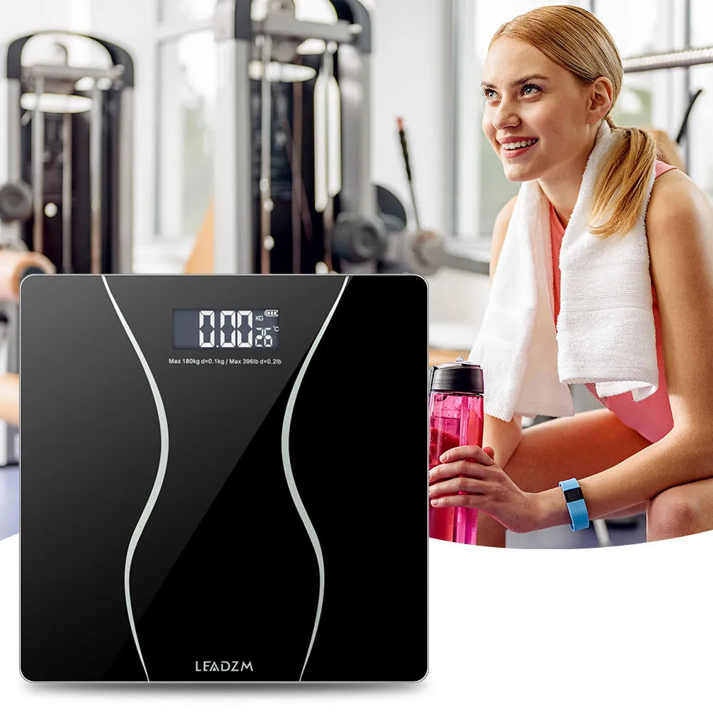Black digital electronic bathroom scale on a tiled floor, showing digital display.