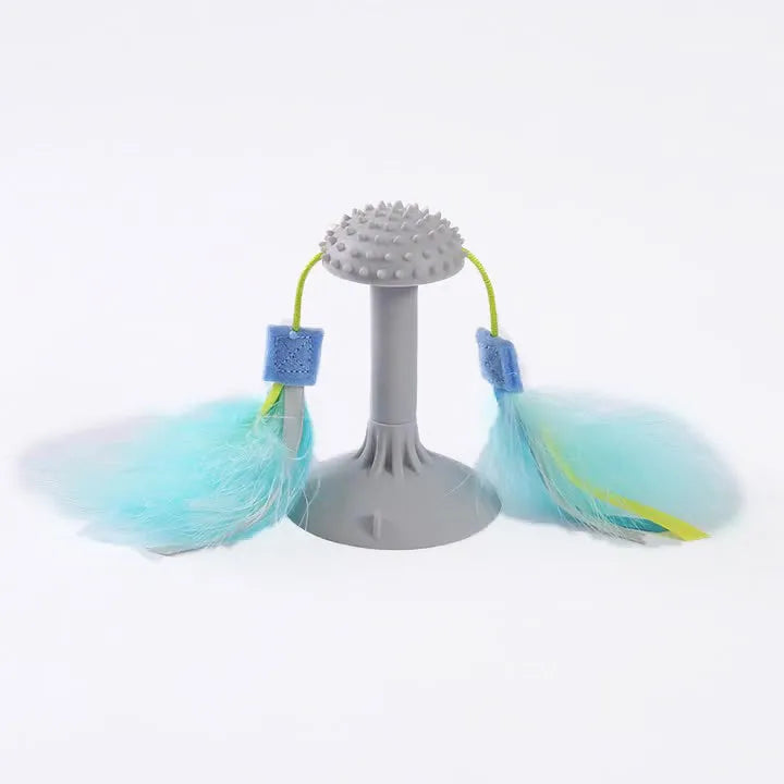 Blue cat toy wand with double haired prick head and suction cup base on a window