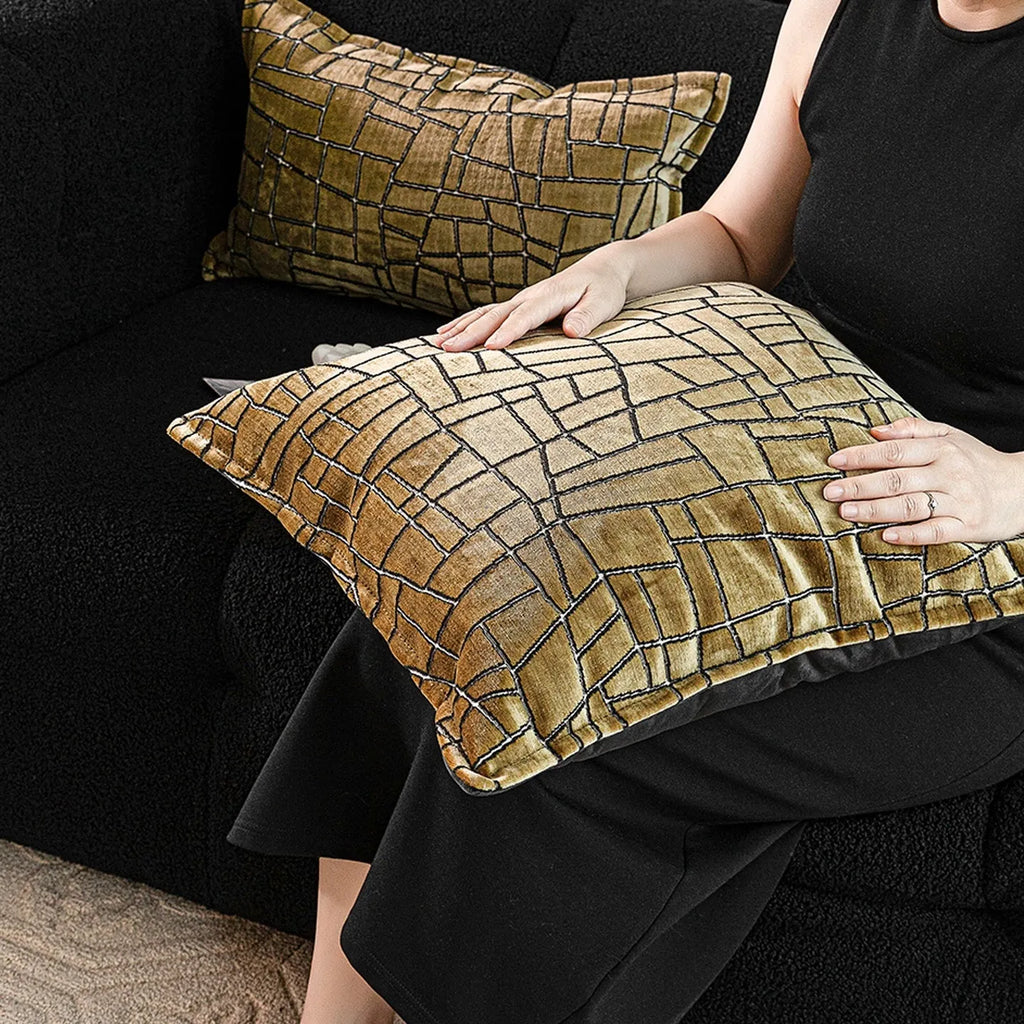 Geometric abstract patterned cushion cover in gold colour on a grey sofa, showing three size options.