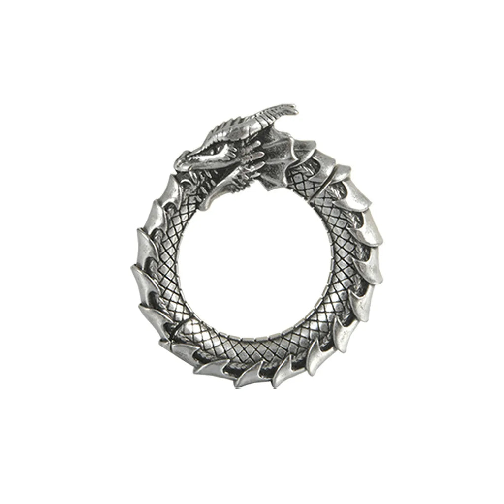 Pair of large antique silver dragon-shaped geometric ear cuffs with hollow-out detail on a plain background.