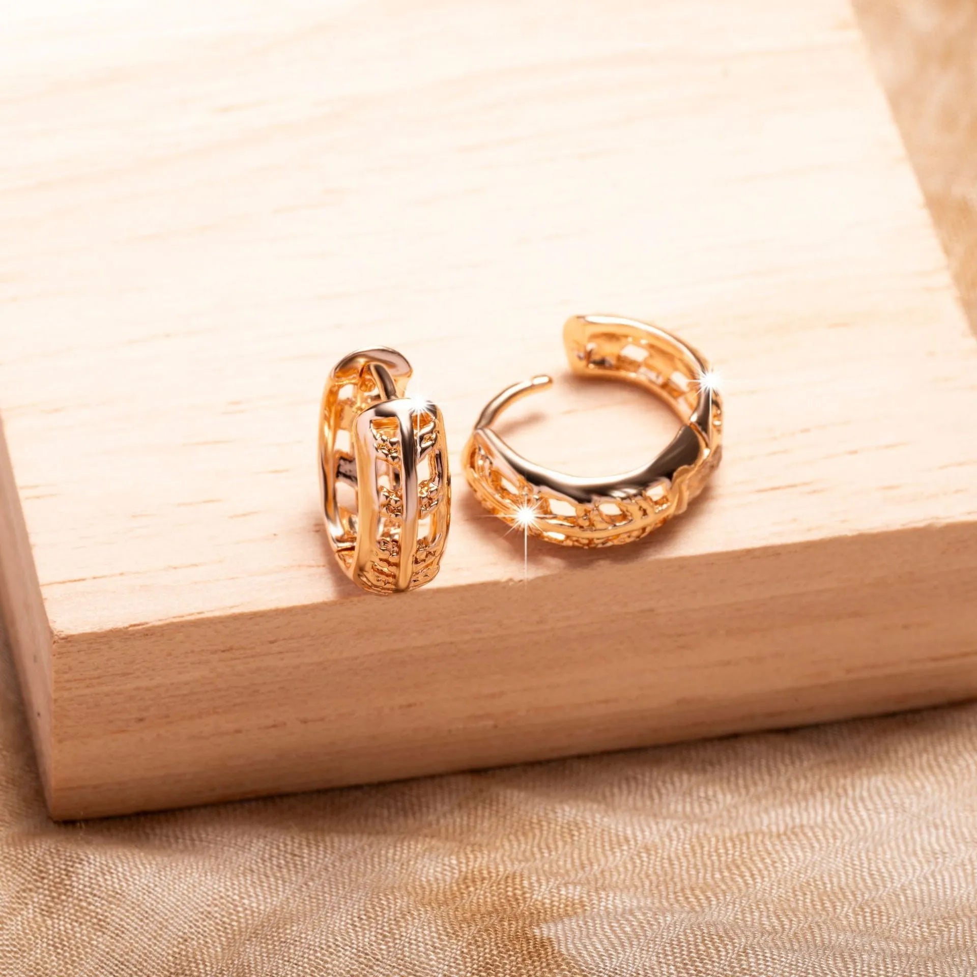 Rose gold coloured copper earrings with a hollowed-out leaf design on a heart shape.