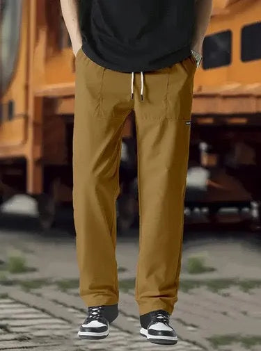 Men's light grey polyester trousers for spring and autumn casual wear, laid flat.