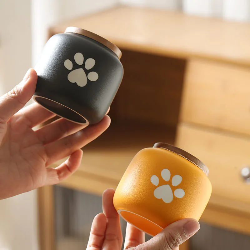 Ceramic pet funeral urn with foot print design in orange colour