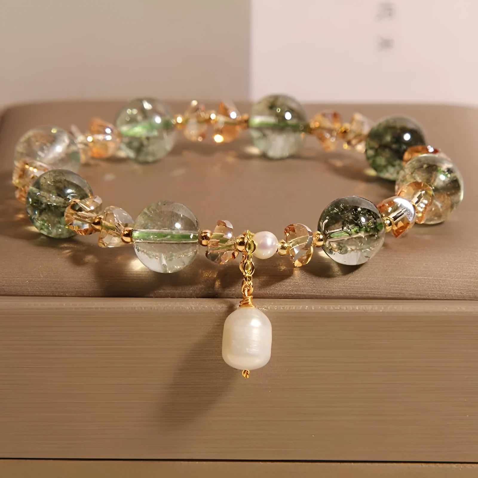 Adjustable green phantom quartz and champagne crystal bead bracelet on a string cord.
