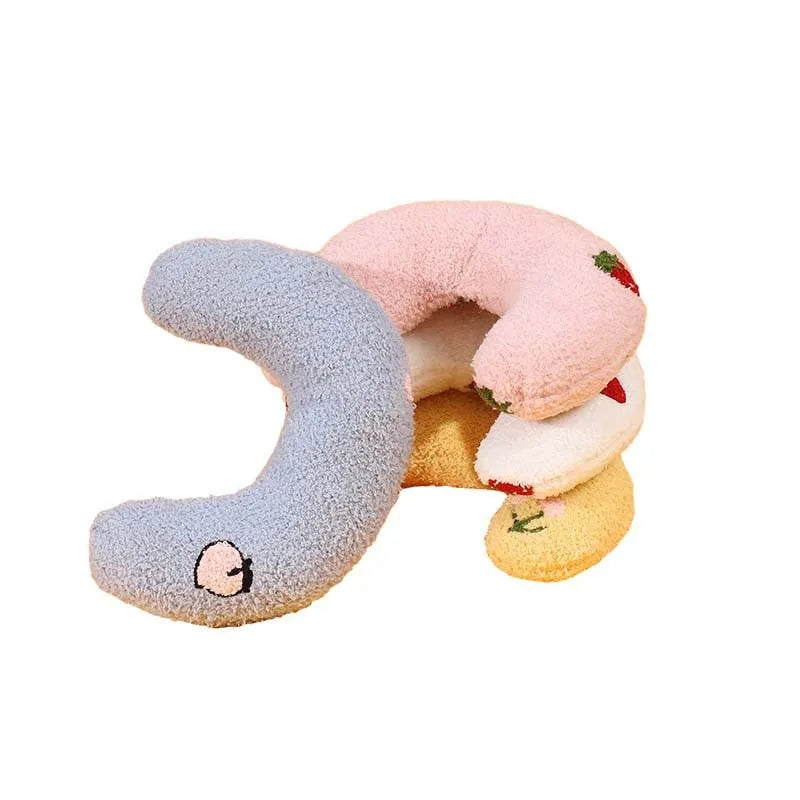 Yellow half-moon shaped cloth pillow with cartoon design for cats and dogs to sleep on.