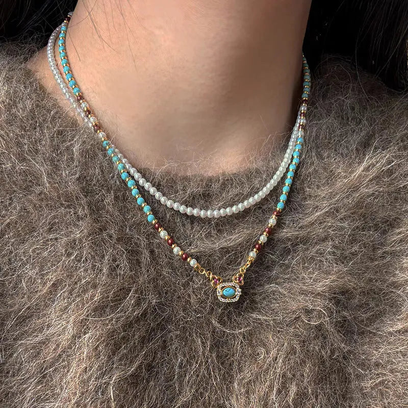 Natural turquoise pearl necklace with gold plated copper chain and matching bracelet on display