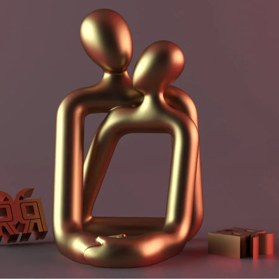 Modern loving couple resin statue in milky white or gold colour on a wooden desk.