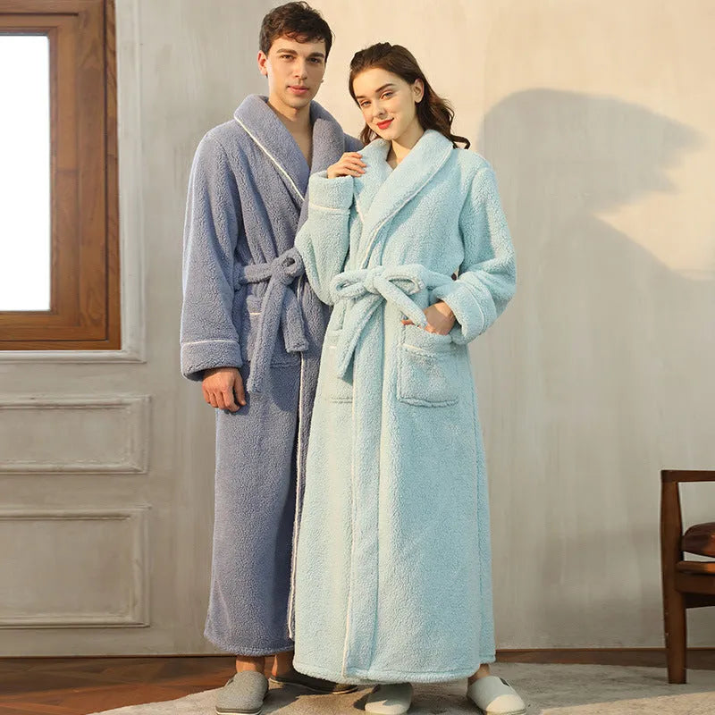 A man and woman wearing matching thick navy blue flannel nightgown robes in a winter home setting.