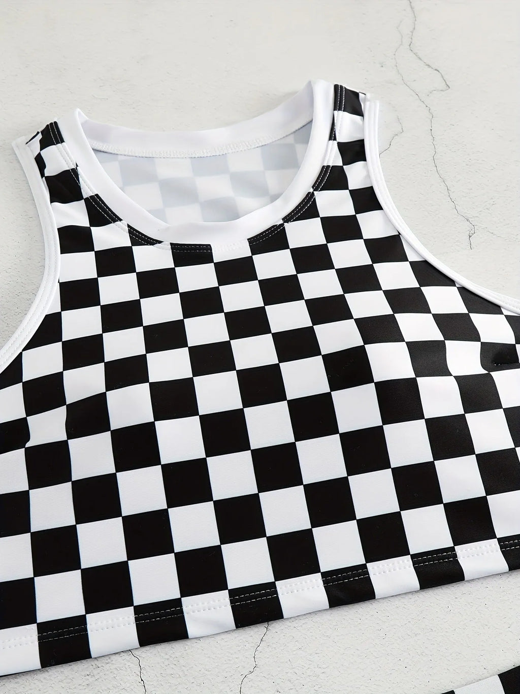 Women's black and white checkerboard racing one-piece swimsuit with backless design and suspender straps