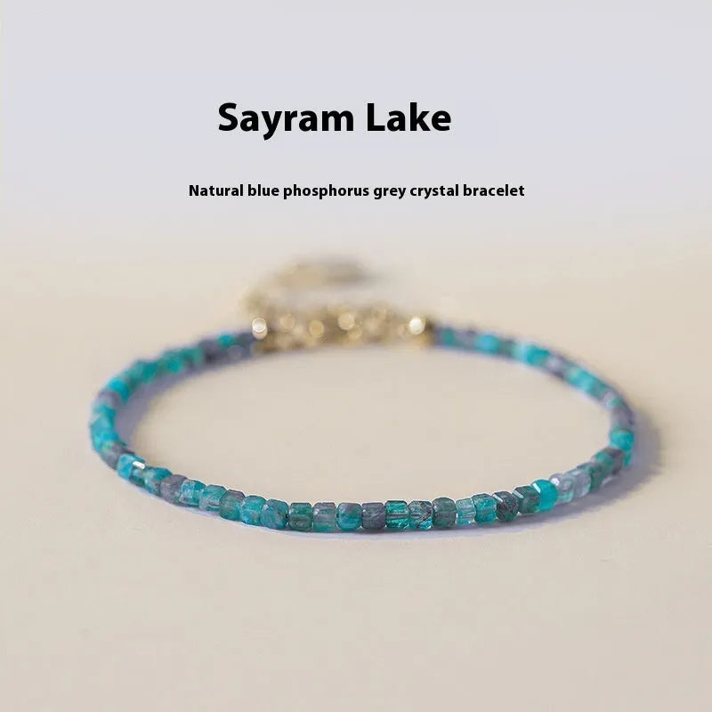 Women's blue and grey apatite crystal bracelet with diamond-cut stones on a wrist.