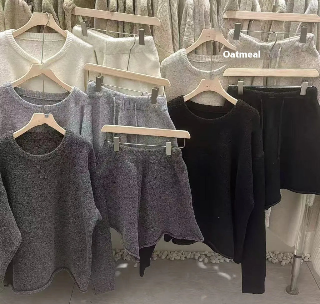 Women's loose-fitting grey acrylic knitted long sleeve sweater and wide leg shorts two-piece set.
