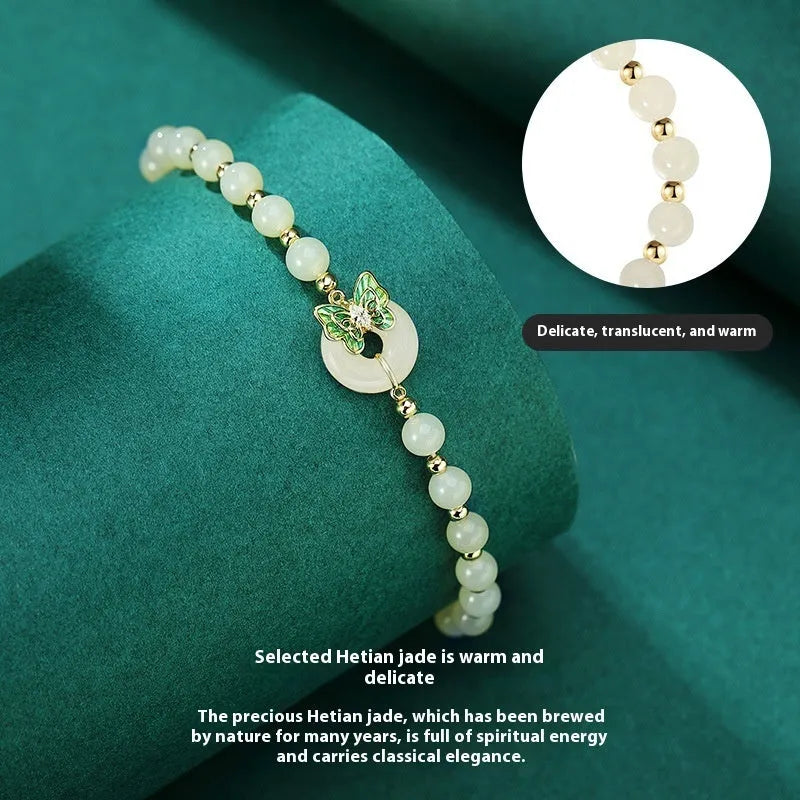 Cyan Hetian jade bracelet with sterling silver butterfly design and gemstone inlays on wrist
