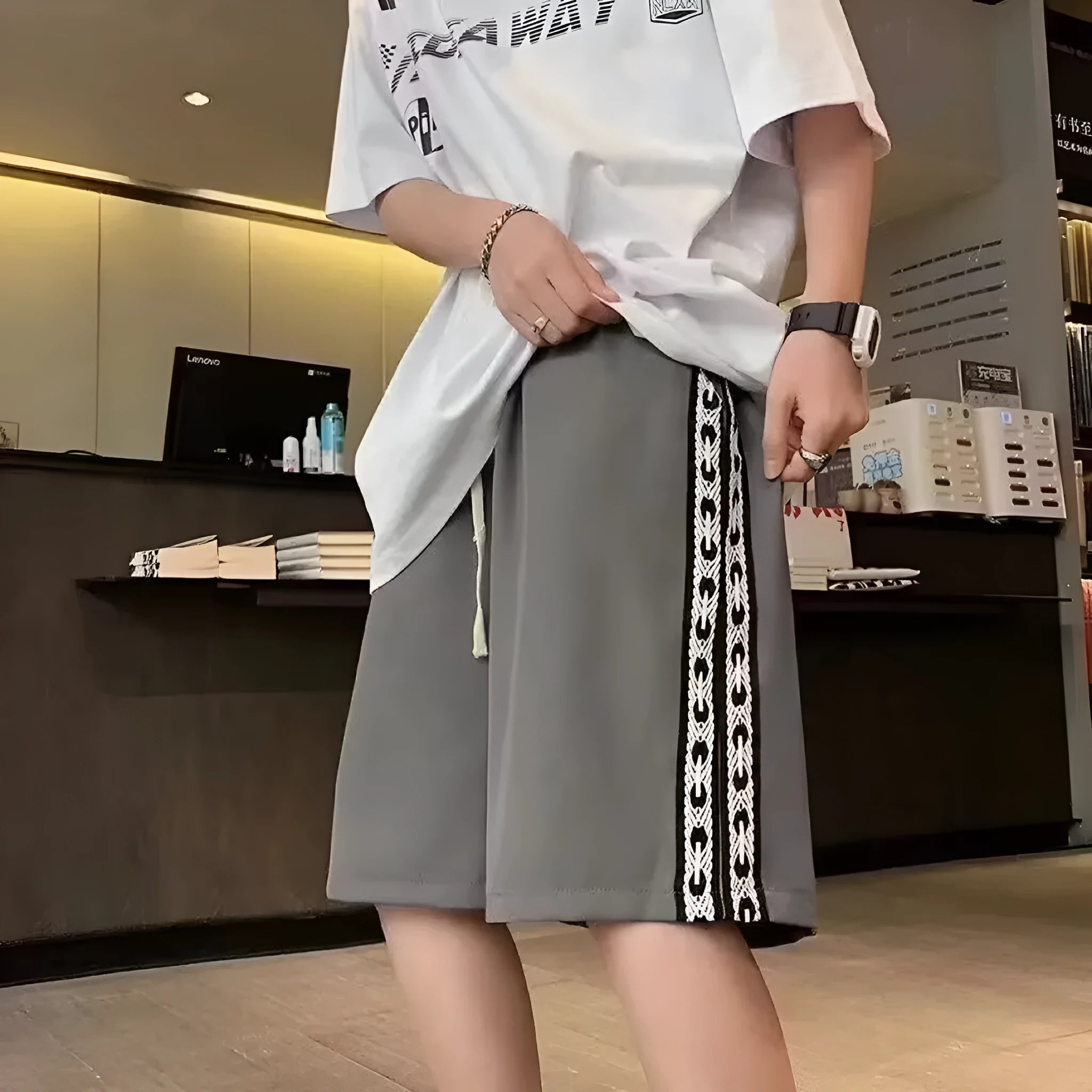 Man wearing loose-fit black track pants, showcasing the baggy sports style and elastic waist.