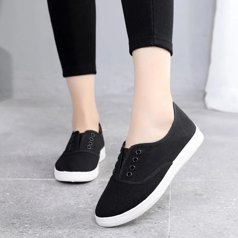 Low-top canvas casual shoes in black, shown on a flat heel with a breathable canvas upper.