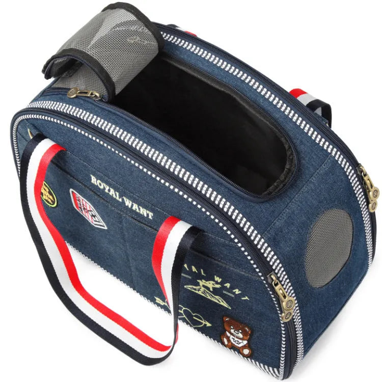 Blue cartoon-patterned denim pet nappy bag with shoulder strap.