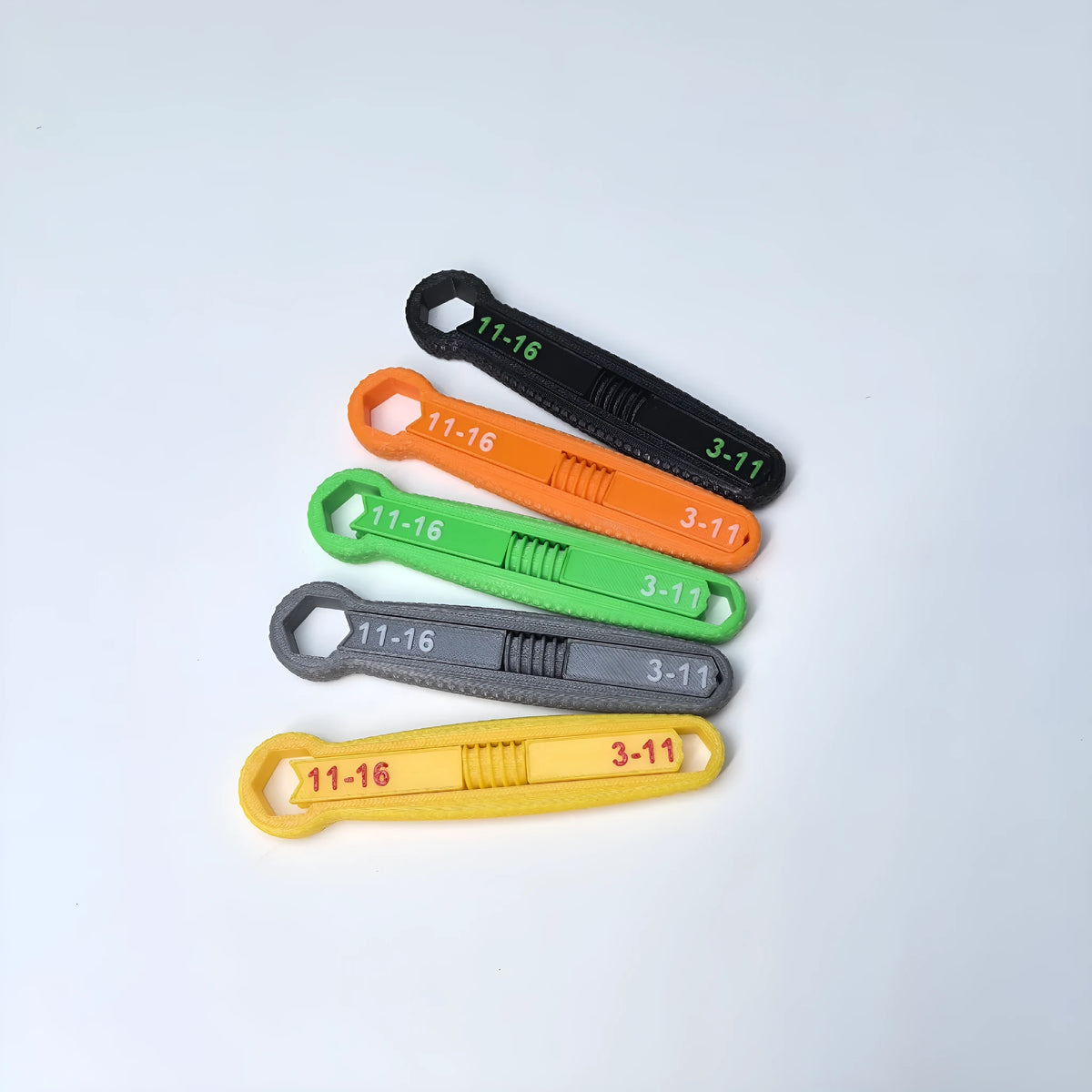 Plastic multi-function opening tool in five colours: black, gray, green, orange, yellow on white background