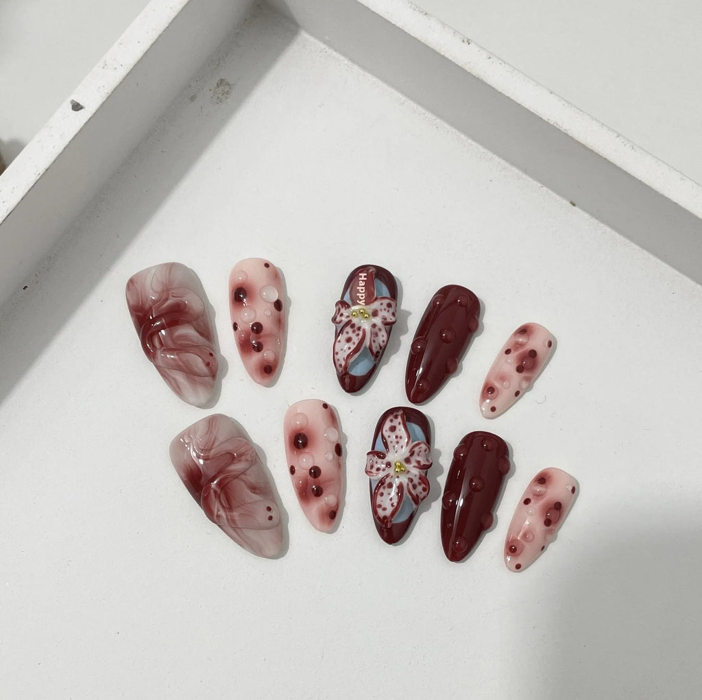 Hand-painted 3D sculpted press-on false nails with multiple patterns in almond shape