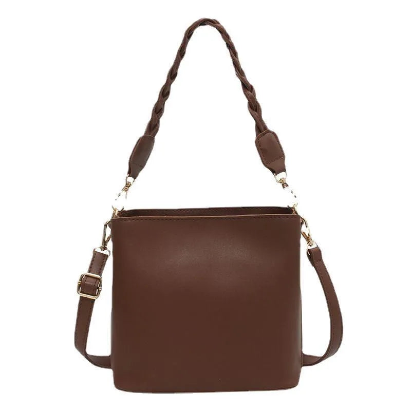 Woven pattern PU leather crossbody bucket bag worn underarm, shown in khaki colour.