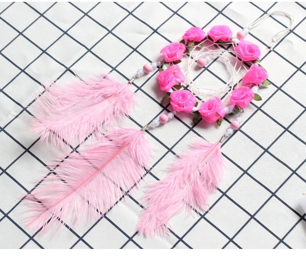 Close-up of a modern pink ostrich feather dreamcatcher wind chime wall ornament.