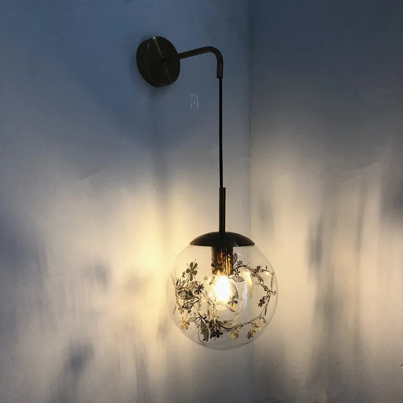Modern creative wall-mounted bedside lamp with a golden flower glass shade and warm LED light.