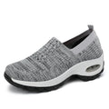 Women's mesh sports shoes in black, side view, showing breathable upper, thick bottom sole, and slip-on design