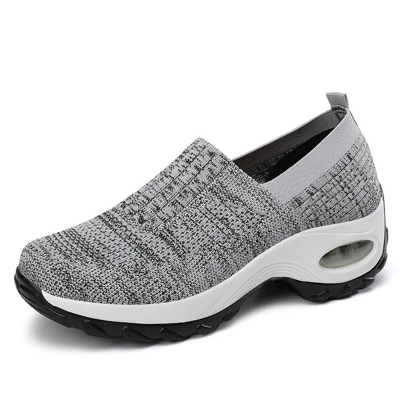 Women's mesh sports shoes in black, side view, showing breathable upper, thick bottom sole, and slip-on design