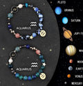 Set of twelve black cord bracelets with natural stone beads engraved with zodiac symbols.