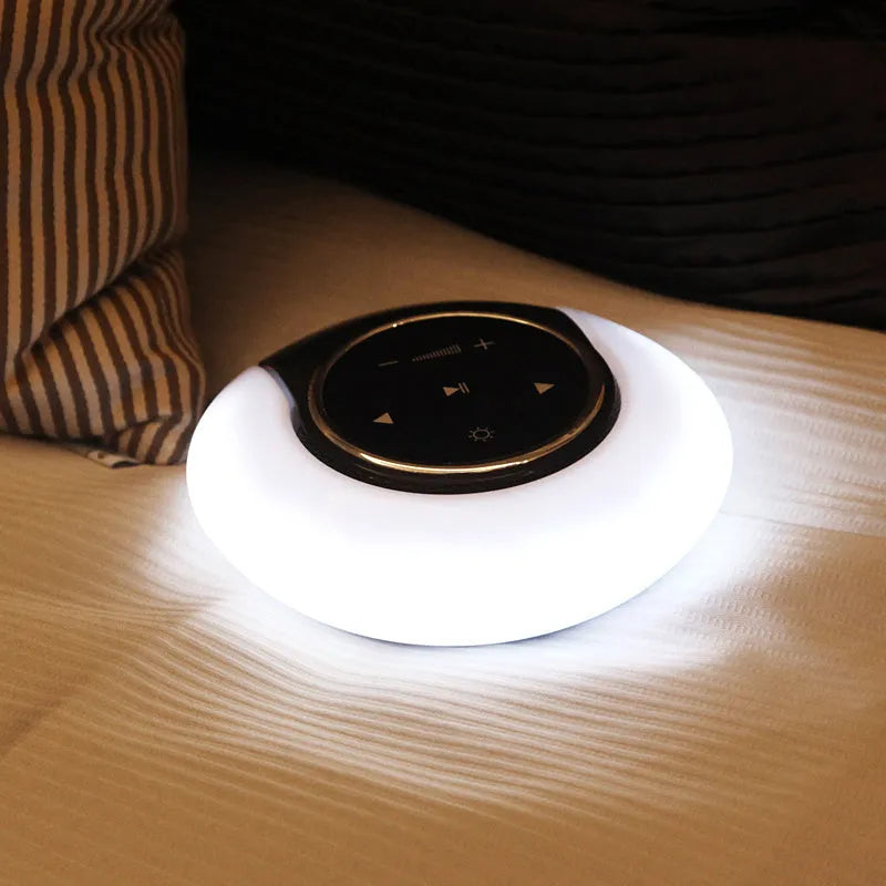 Folding Bluetooth desk lamp and speaker with touch controls showing blue atmospheric LED light.