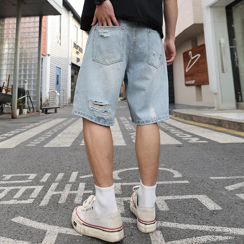 Light blue loose fit distressed denim shorts with ripped detailing and straight leg design