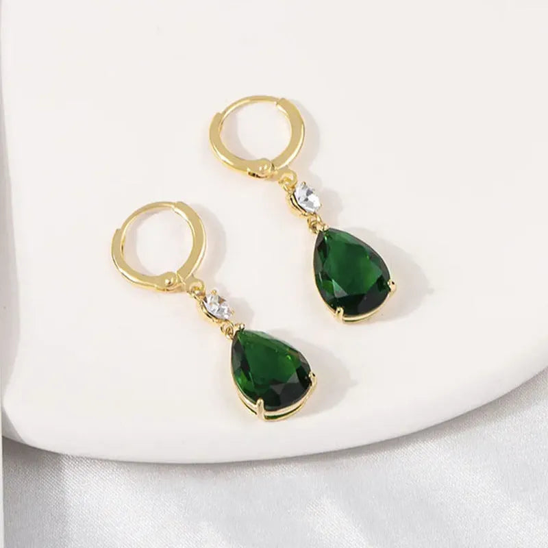 Pair of green geometric teardrop-shaped alloy earrings on a white background.