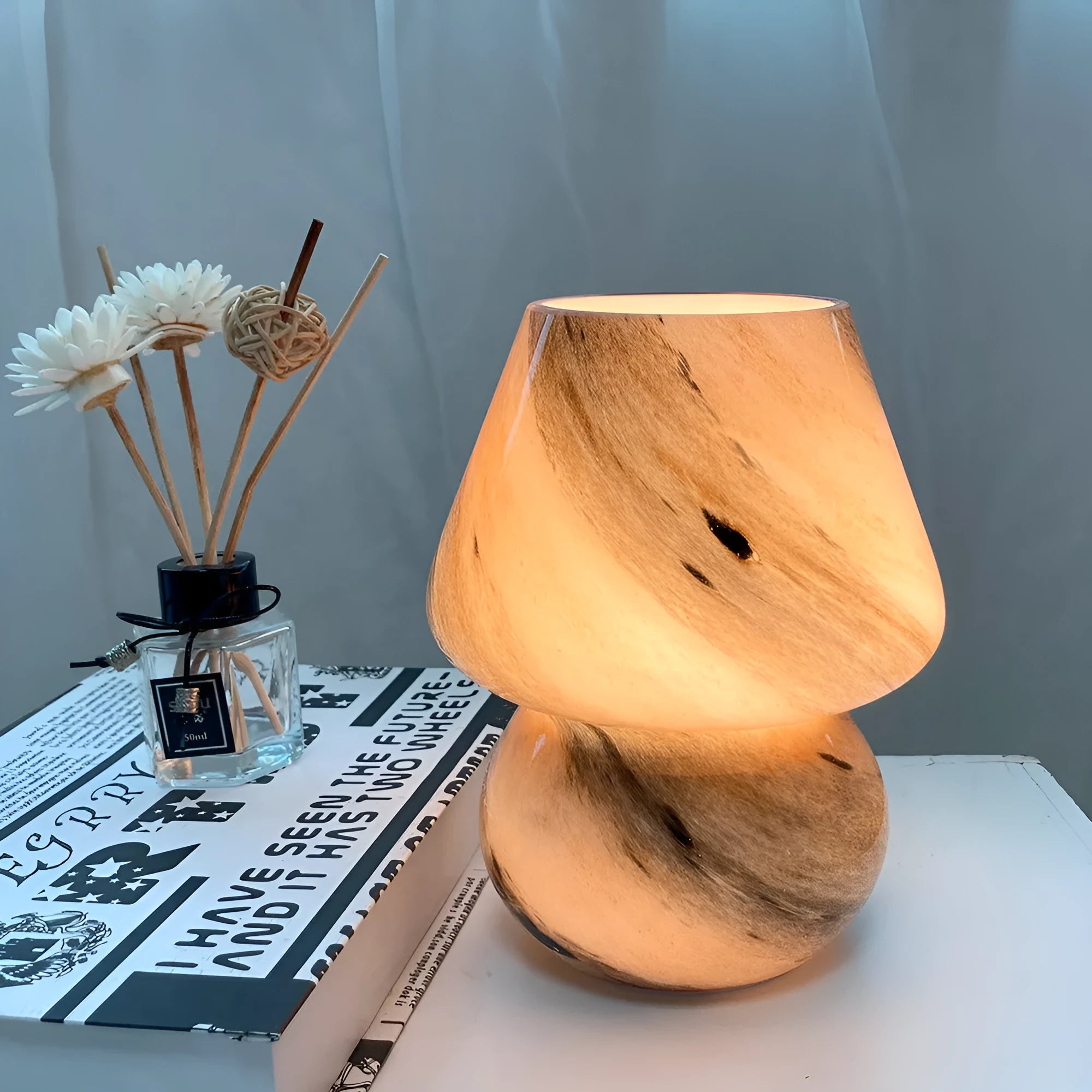 Handmade glass mushroom table lamp in Earth colour finish on a bedside table, showing its compact 15x19cm size