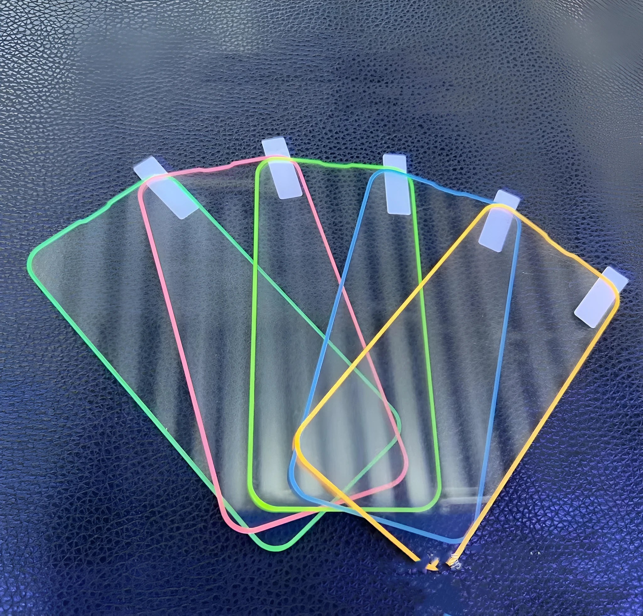 Fluorescent pink tempered glass screen protector fitted on an iPhone 13, showing full-screen coverage and luminous glow.