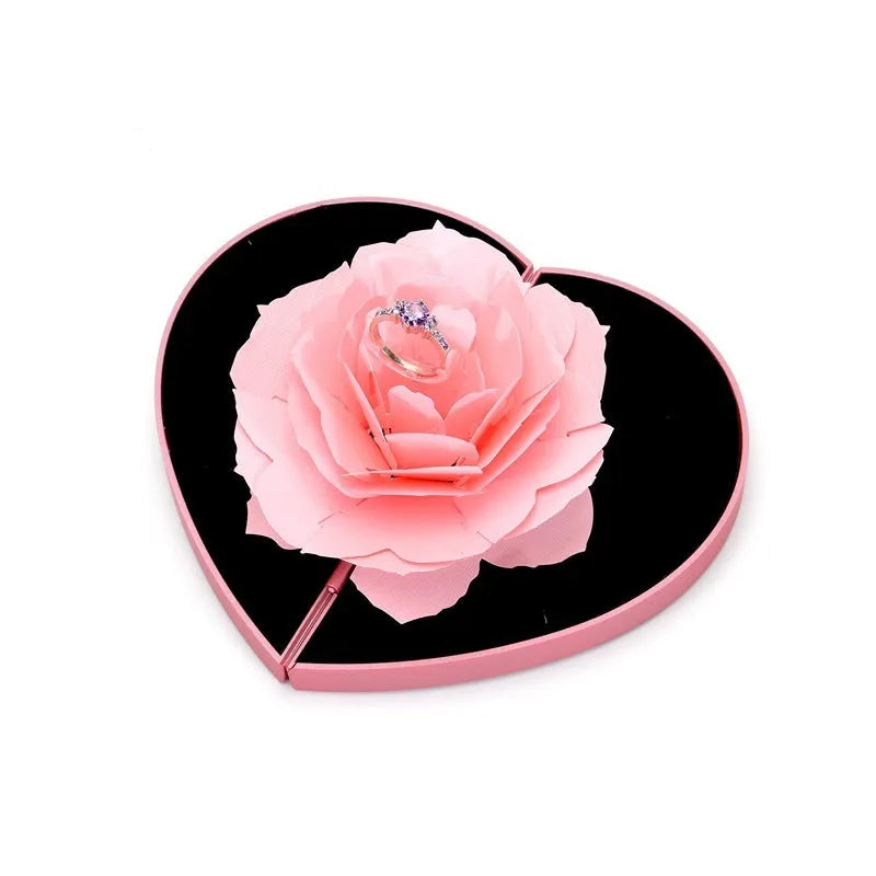 Red rotating 3D heart-shaped plastic ring box with a rose, open to show ring placement.