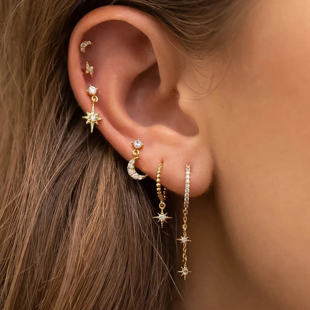 Six gold-coloured chain tassel earrings with zircon stones arranged together