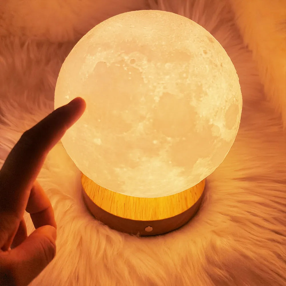 Rotating moon night lamp on a wooden base showing three colour light modes.