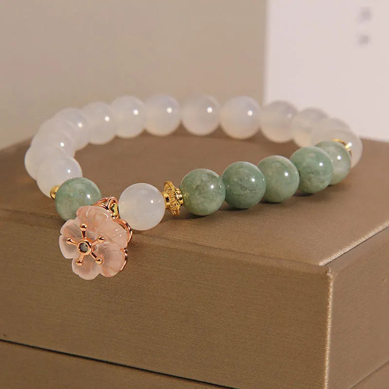 White agate jade flower bracelet with pink accent stones on wrist
