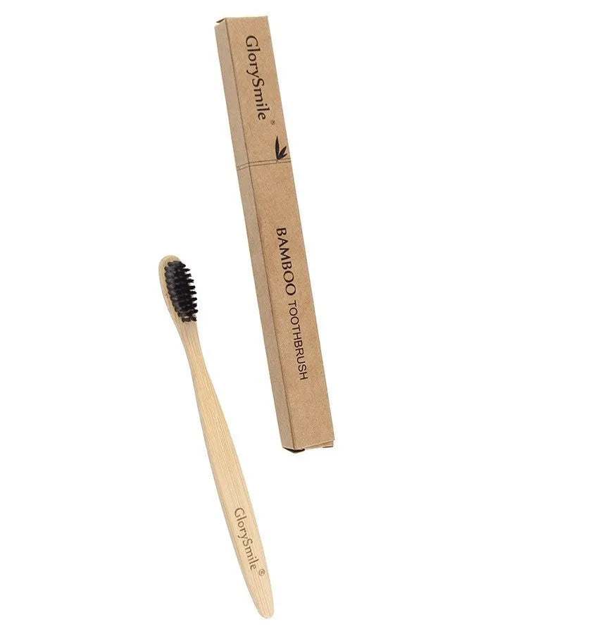 Natural bamboo toothbrush with black charcoal bristles on a white background