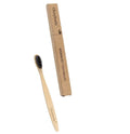 Natural bamboo toothbrush with black charcoal bristles on a white background