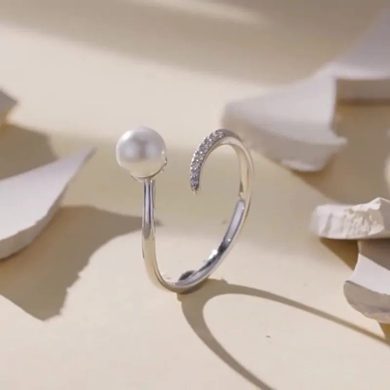 Close-up of an adjustable S925 sterling silver ring featuring a natural shell pearl on an open loop band.