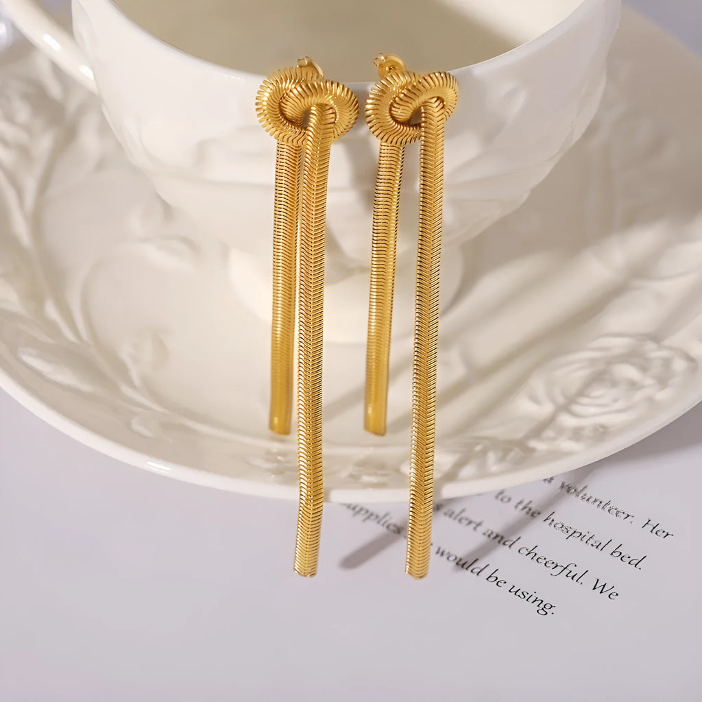 Gold titanium steel knotted tassel necklace and matching earrings set on white background