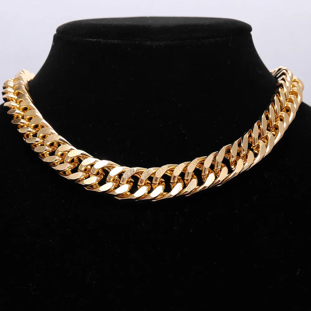 Gold electroplated women's necklace with thick chain and teardrop pendant on a grey background.