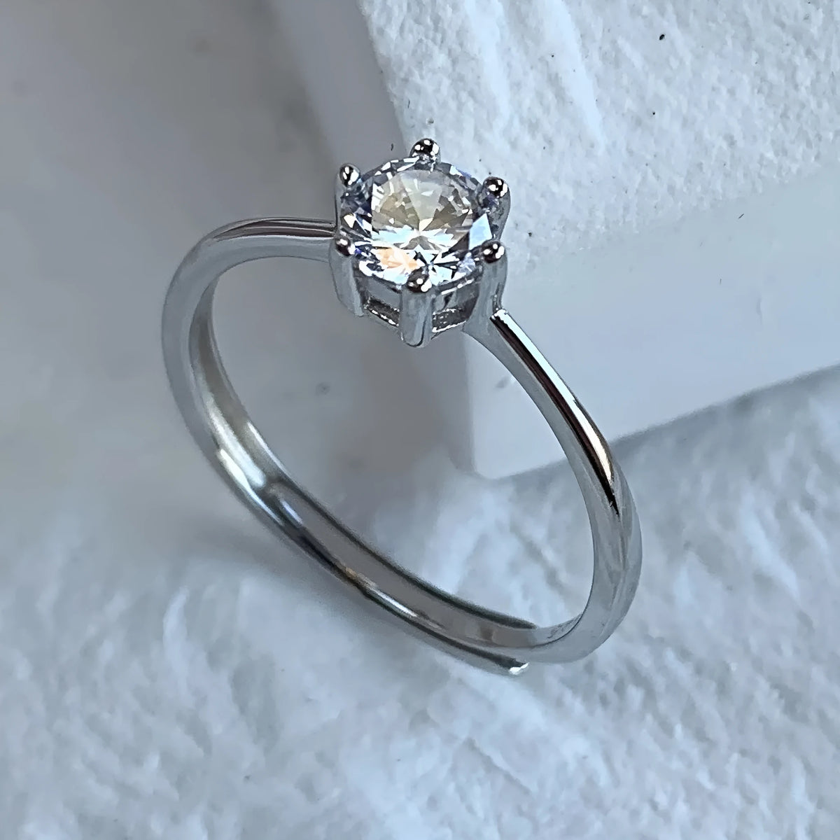 Sterling silver adjustable ring with round zircon in six-claw setting, open mouth band, geometric design