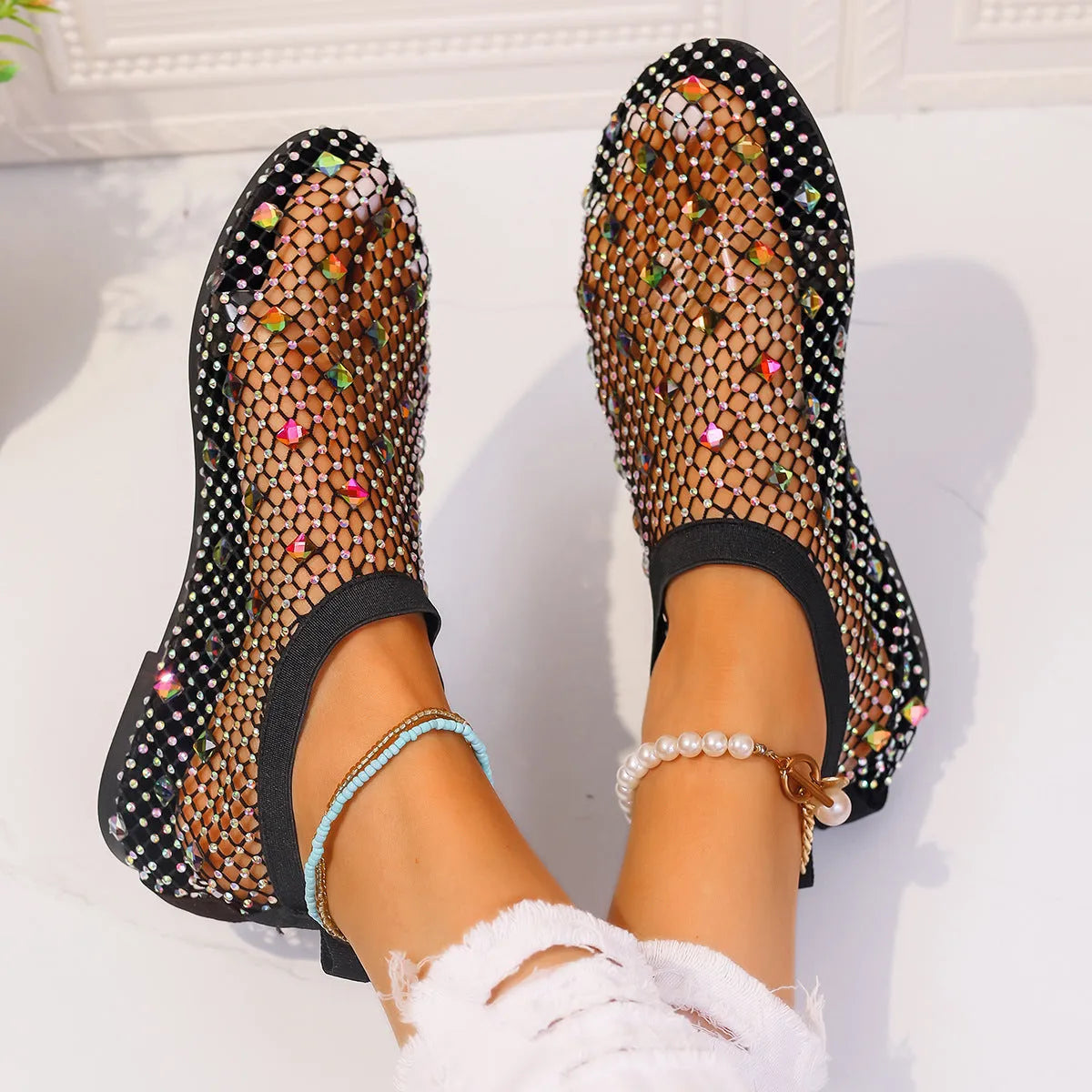 Women's white and colourful mesh flat sandals with rhinestone decoration and a round toe.