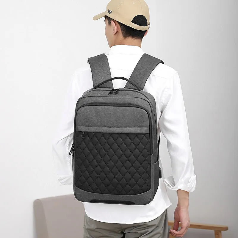 Men's Oxford cloth travel backpack in black with curved shoulder strap and diamond mesh detail